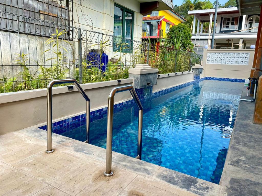a swimming pool with blue water in front of a building at Villa kota bunga 3 BR Kolam renang pribadi in Cipanas