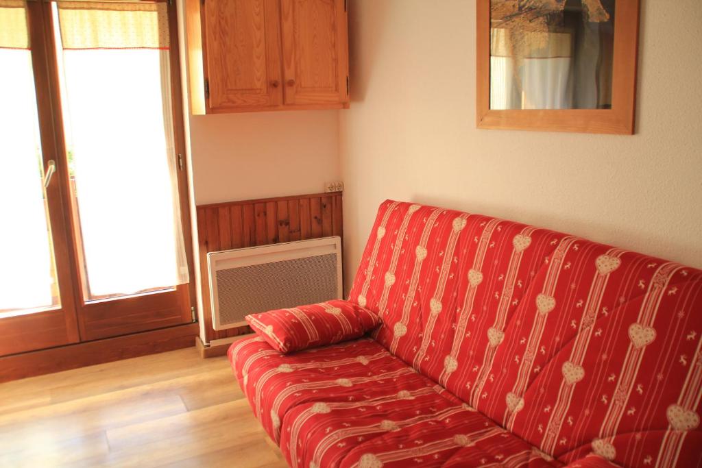 - un salon avec un canapé rouge dans l'établissement Gentianes GNA17 COSY & MOUNTAIN 4 Pers, à Châtel