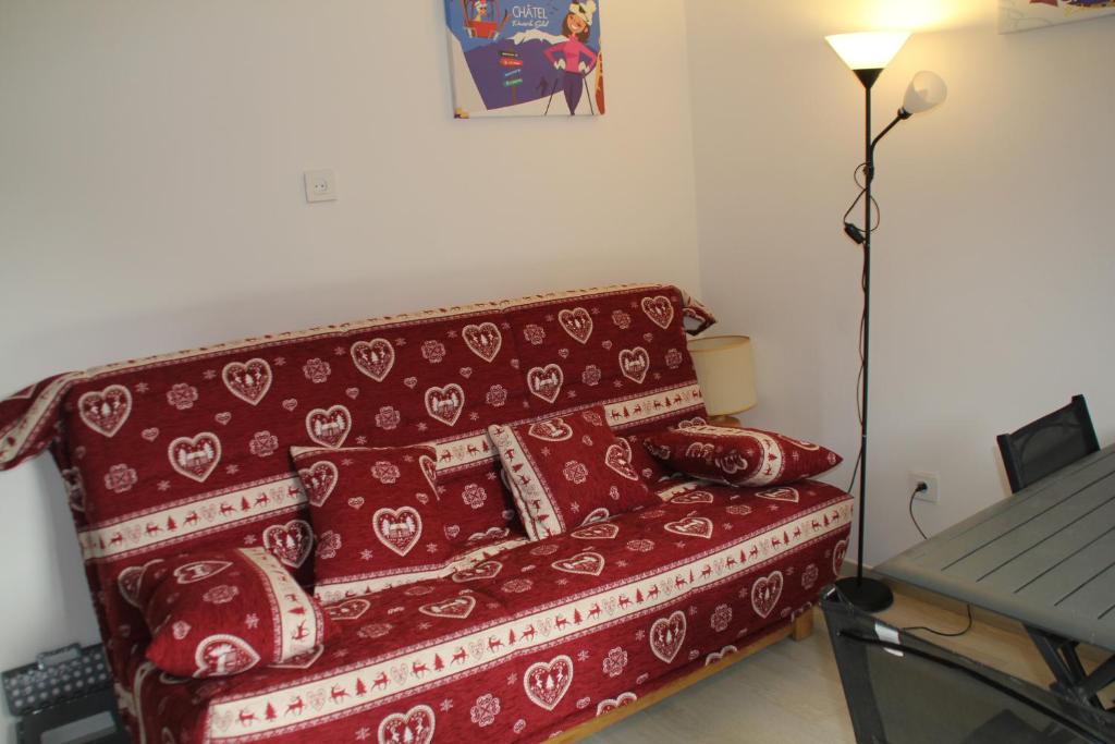 - un canapé rouge avec des oreillers dans l'établissement Gentianes GNA15 MOUNTAIN 1 QUIET 3 Pers, à Châtel