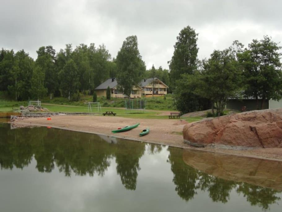 a lake with two kayaks on the shore and a house at Loghouse in Hjorto in Ödkarby