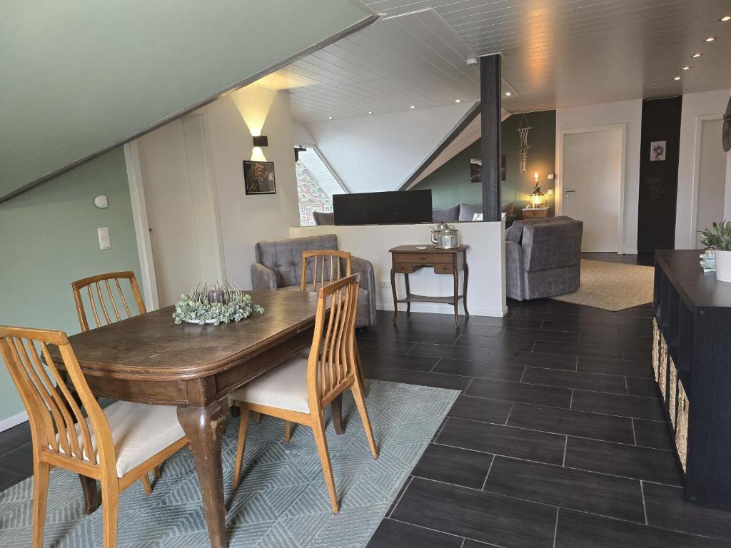 a dining room and living room with a wooden table and chairs at Großzügige Ferienwohnung in Weilburg