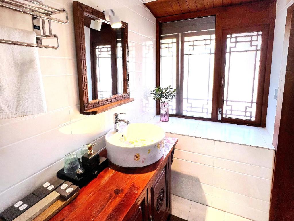 a bathroom with a sink and two windows at 原乡文苑客栈 in Lijiang