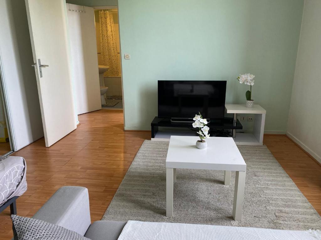 un salon avec une table blanche et un canapé dans l'établissement Appart calme avec parking gratuit, à Évry-les-Châteaux