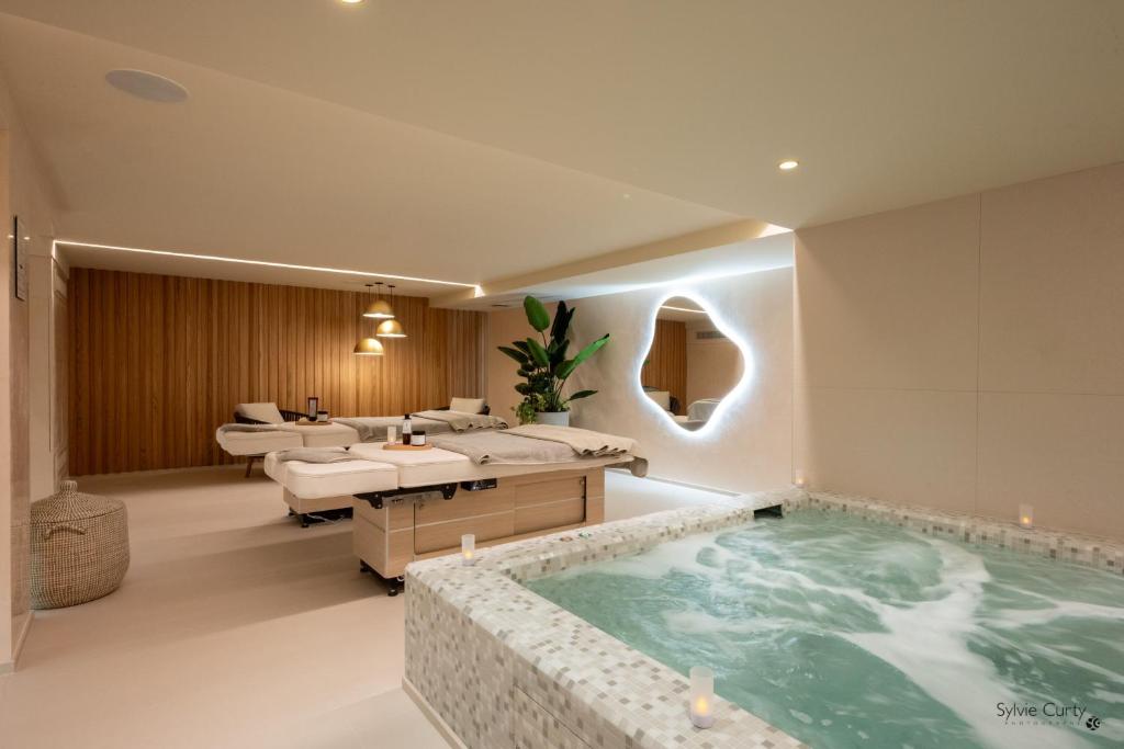 a bathroom with a large bath tub in a room at Hôtel La Monnaie Arty & Spa in La Rochelle