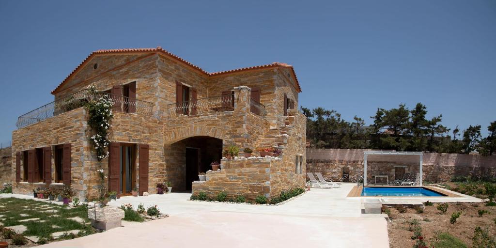 a brick house with a swimming pool in front of it at The Stone Project in Ermoupoli