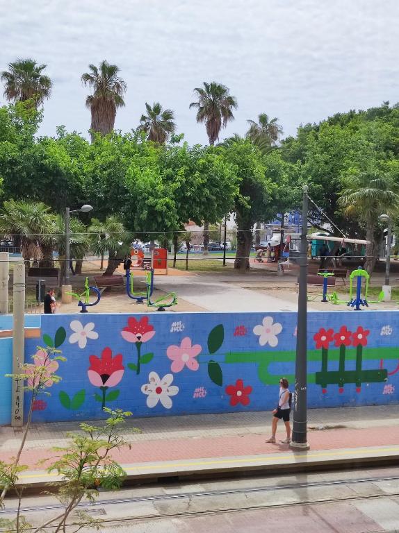 Una mujer caminando junto a un muro en un parque. en Bright loft near the sea BIKES, en Valencia