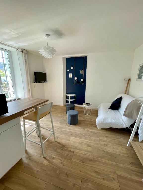 - un salon avec un bureau et un lit dans l'établissement STUDIO parfaitement agencé, à Lamballe