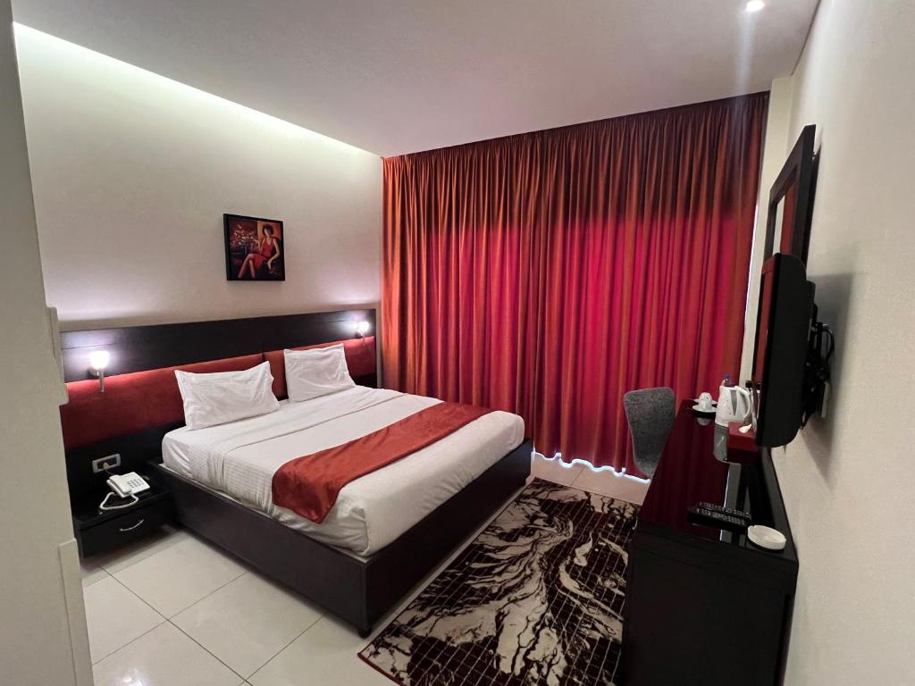 a hotel room with a bed and a red curtain at Duroy Hotel in Beirut