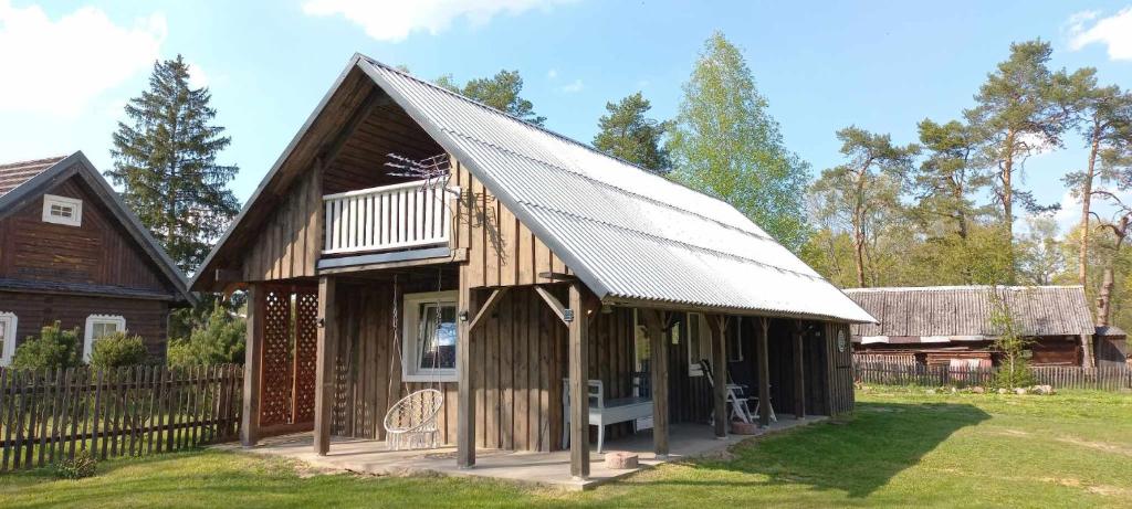 una pequeña casa de madera con techo de metal en Ramintos miško namelis en Žiogeliai