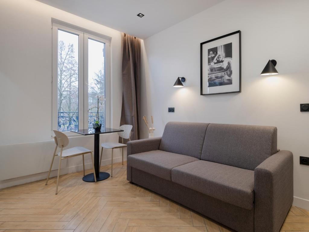 un salon avec un canapé et une table dans l'établissement Charming Studio in Pantin, à Pantin