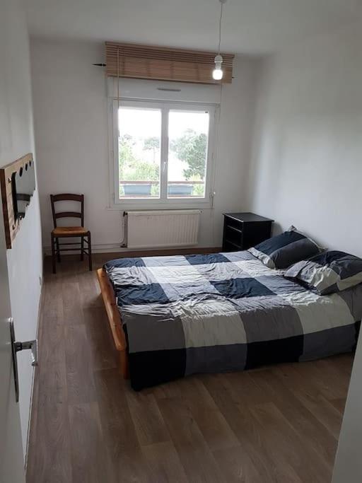 une chambre avec un lit dans une pièce avec une fenêtre dans l'établissement Appartement t3 privatif 56m2 La Baule proche mer, à La Baule