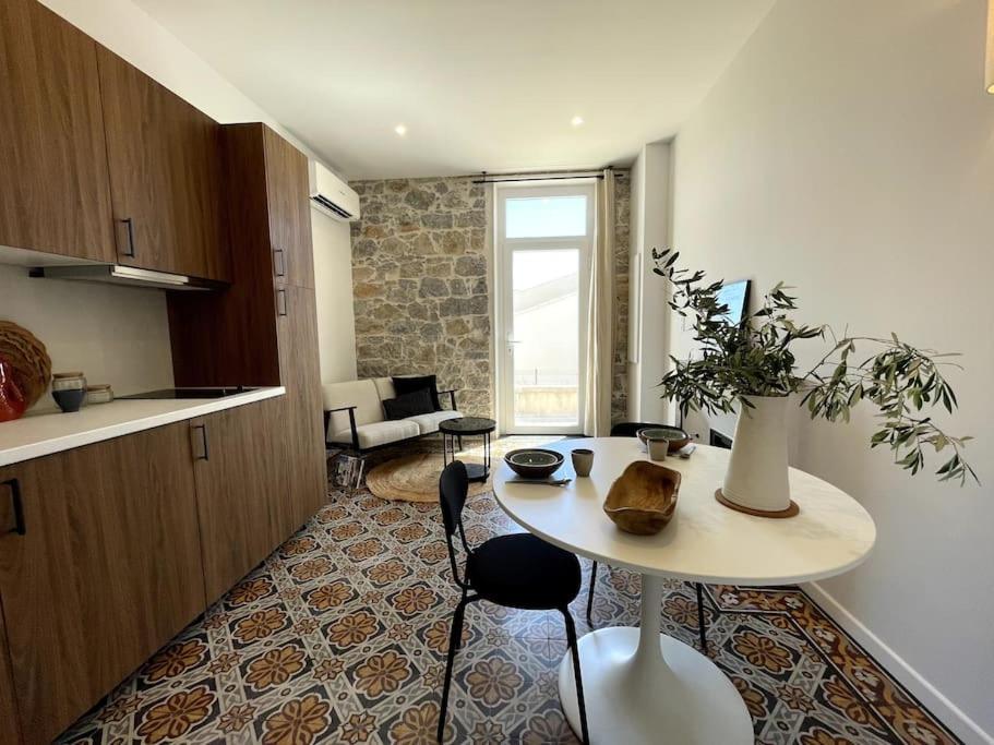 une cuisine et un salon avec une table et des chaises dans l'établissement Appartement cosy, climatisé et central à deux pas de la mer !, à Carqueiranne