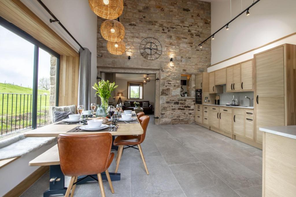 a kitchen and dining room with a table and chairs at Canny Grouse Barn in Kirkby Stephen