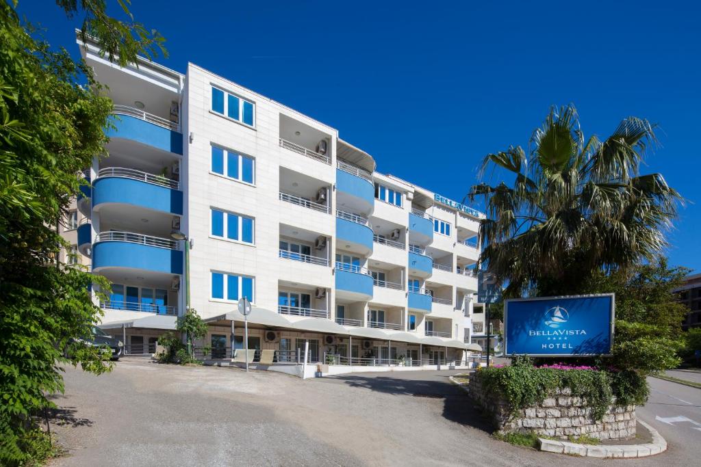 an apartment building with a sign in front of it at Hotel Bella Vista in Budva