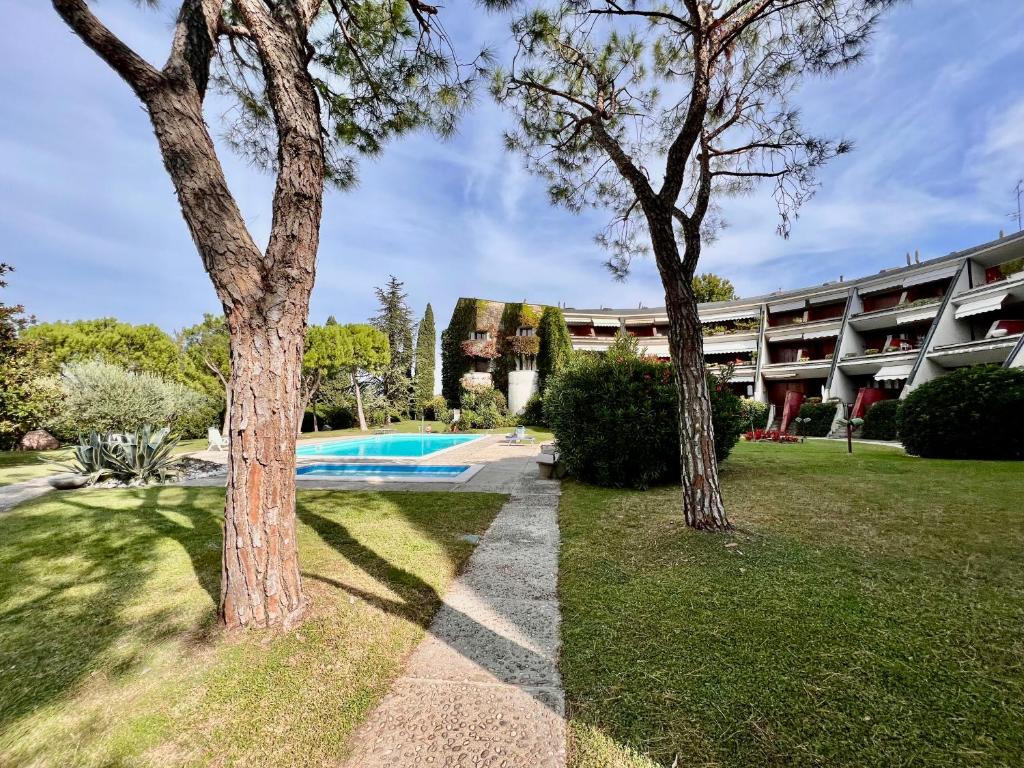 een resort met een zwembad en twee bomen bij OASI in Desenzano del Garda