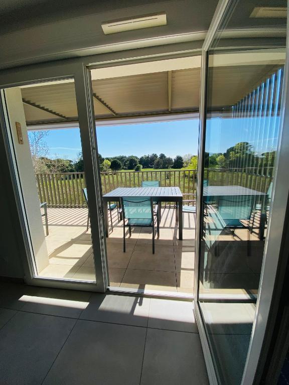 un porche grillagé avec une table et une vue sur un patio dans l'établissement Appart 4 pers climatisé parking piscine proche des plages ménage inclus - V0816, à Vias