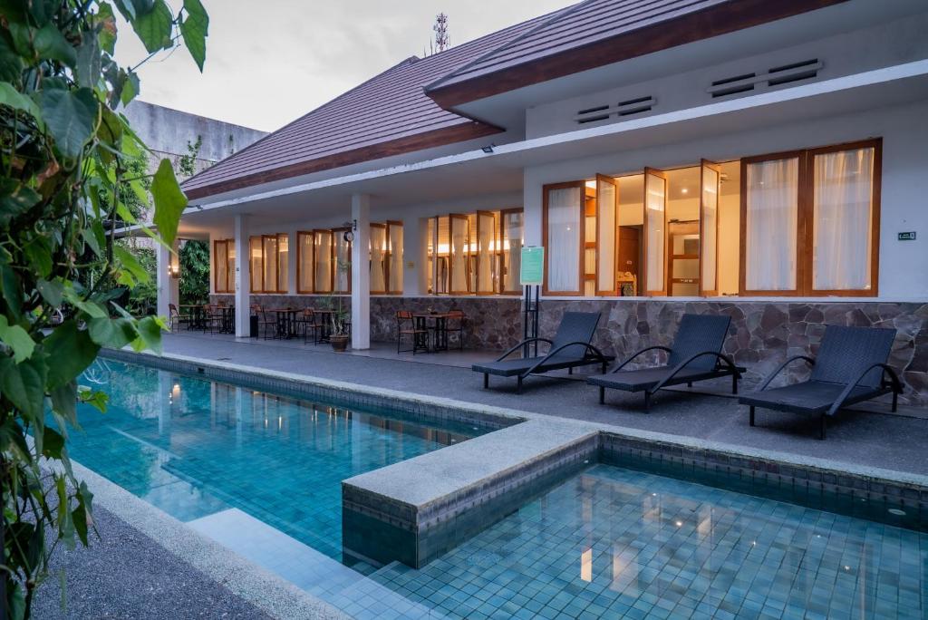 バニュワンギにあるホテル ブランバンガンの建物の隣にプールがある家