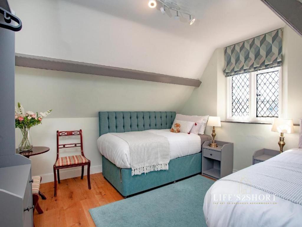 een slaapkamer met een bed en een stoel erin bij Bury Meadow Lodge - Exeter - Train 5 min walk - Parking in Exeter