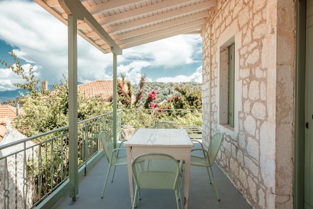 a patio with a table and chairs on a balcony at Teacher's House in Meganisi
