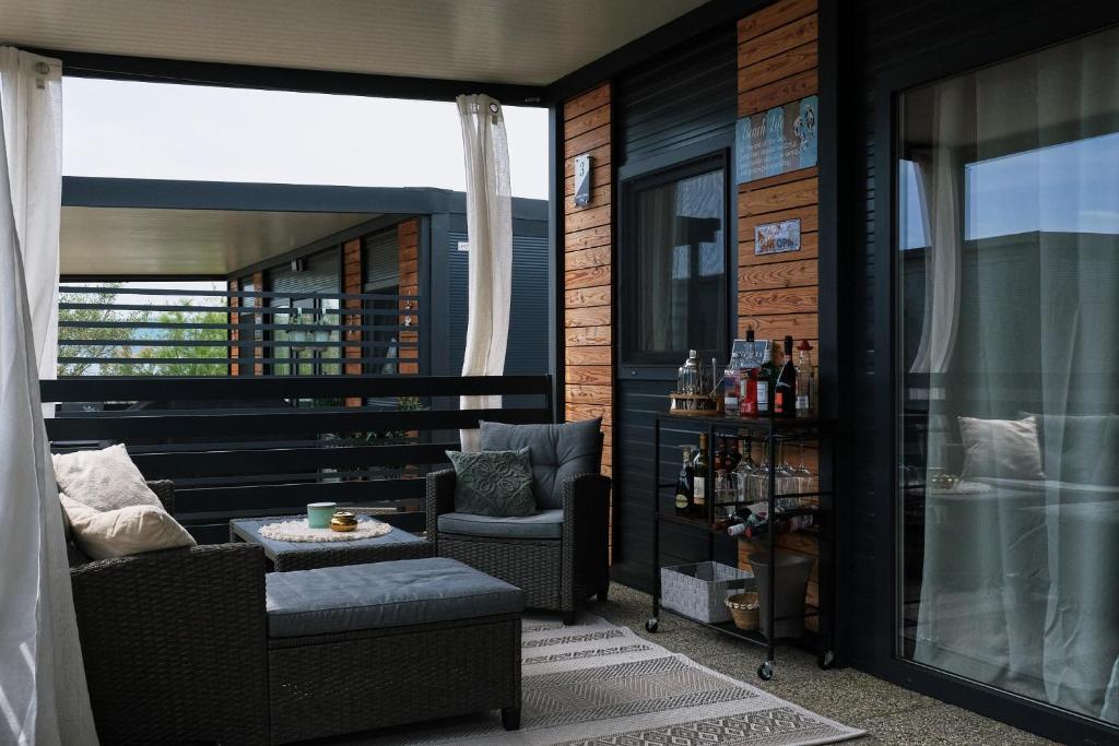a balcony with a chair and a table and a window at Mobile Home Ella in Sveti Petar