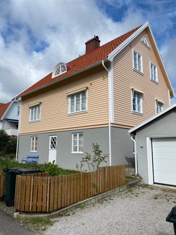 a house with a wooden fence in front of it at Solhyddan, tvårumslägenhet i villa nära havet in Båstad