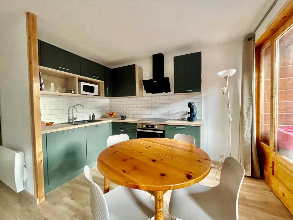 - une cuisine avec une table en bois et des chaises blanches dans l'établissement VAL PIERRE VPS8 CENTER & MODERN 4 Pers, à Châtel