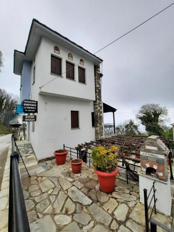 a white building with potted plants in front of it at Milea Byron House Tsagarada in Tsagarada