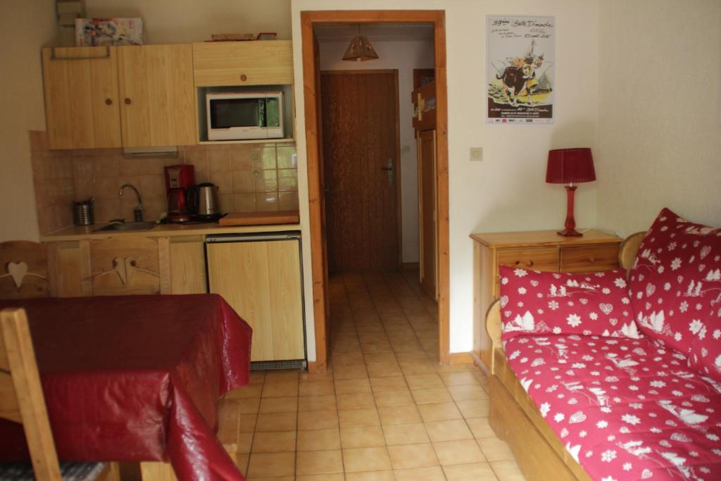 un salon avec un canapé rouge et une cuisine dans l'établissement VOINETTES VNB3 TELECABINE & MOUNTAIN 4 Pers, à Châtel