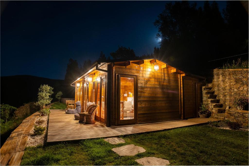 a tiny house with lights on a deck at night at Wood House Amazing View Douro in Raiva