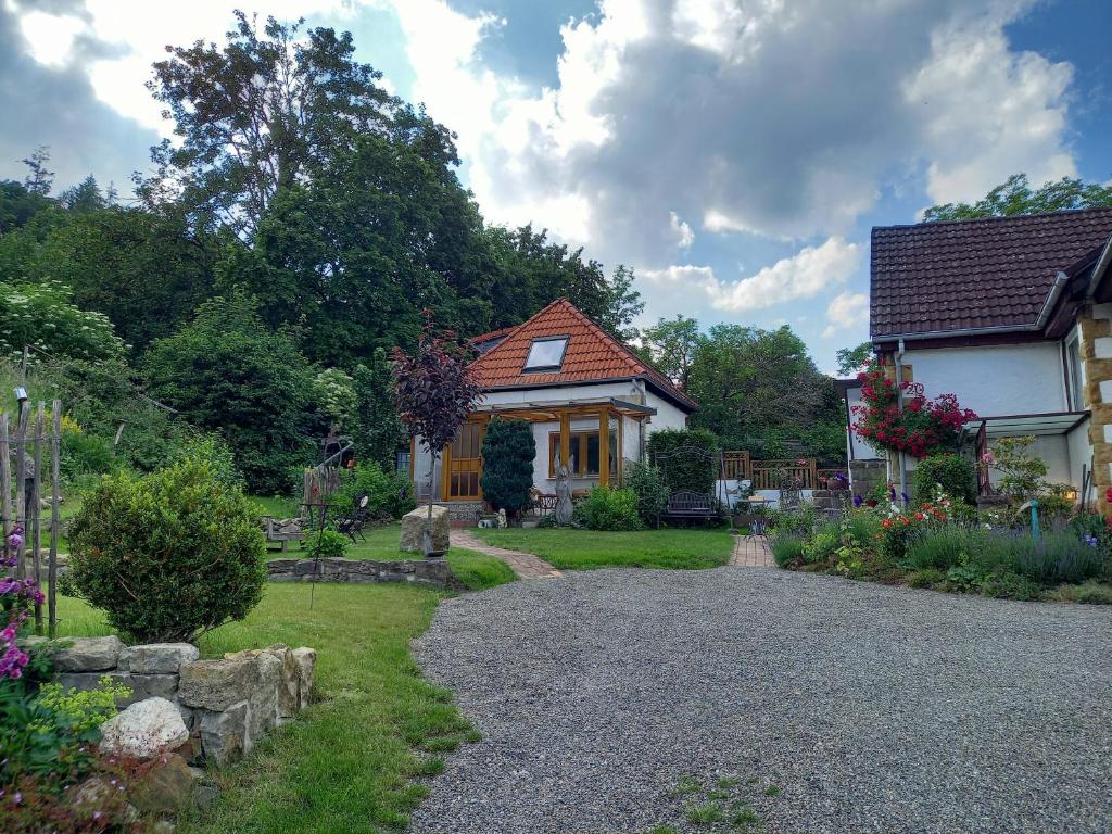 a house with a garden and a gravel driveway at Elfenhäuschen mit 3 DTV Sternen ausgezeichnet in Bad Harzburg