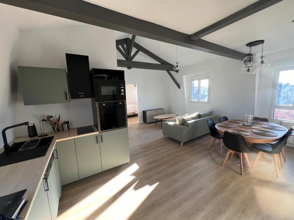 une cuisine et un salon avec une table dans la chambre dans l'établissement L'Hostellerie des Vieux Plats LGT 6, à Gonneville-la-Mallet