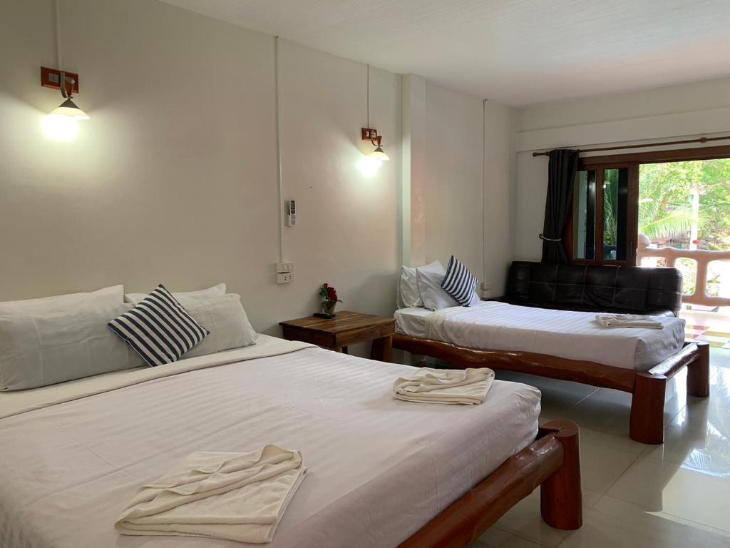 a room with two beds and a window at Paradise Bungalows in Haad Rin