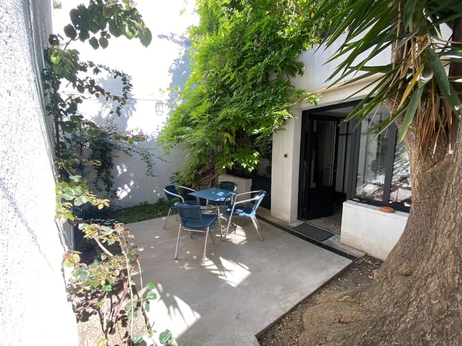 d'une terrasse avec une table, des chaises et un arbre. dans l'établissement Studio proche de la mer, à Marseille