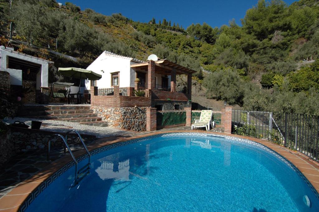 a large swimming pool in front of a house at Cortijo en Frigiliana in Frigiliana