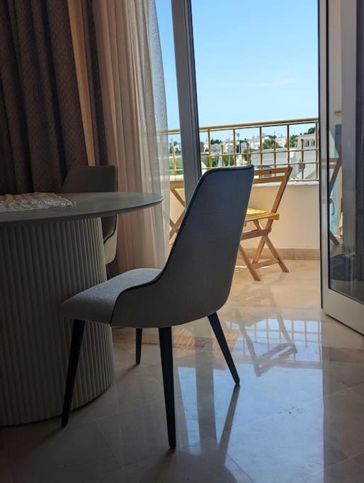 a chair and a table in a room with a balcony at Dar soufia in Nabeul