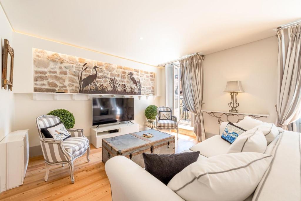 Una sala de estar con un sofá blanco y sillas. en GuestReady - Áurea Art apartment, en Lisboa