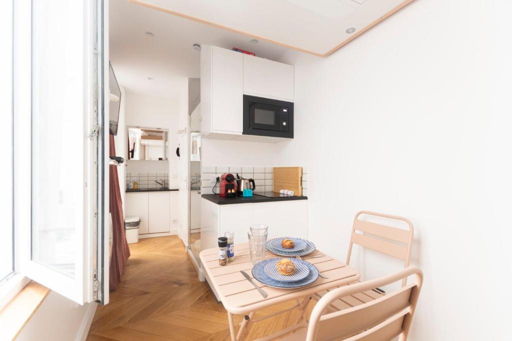 une petite cuisine et salle à manger avec une table et des chaises dans l'établissement Super central mini studio - 2 pax, murphy bed, à Paris