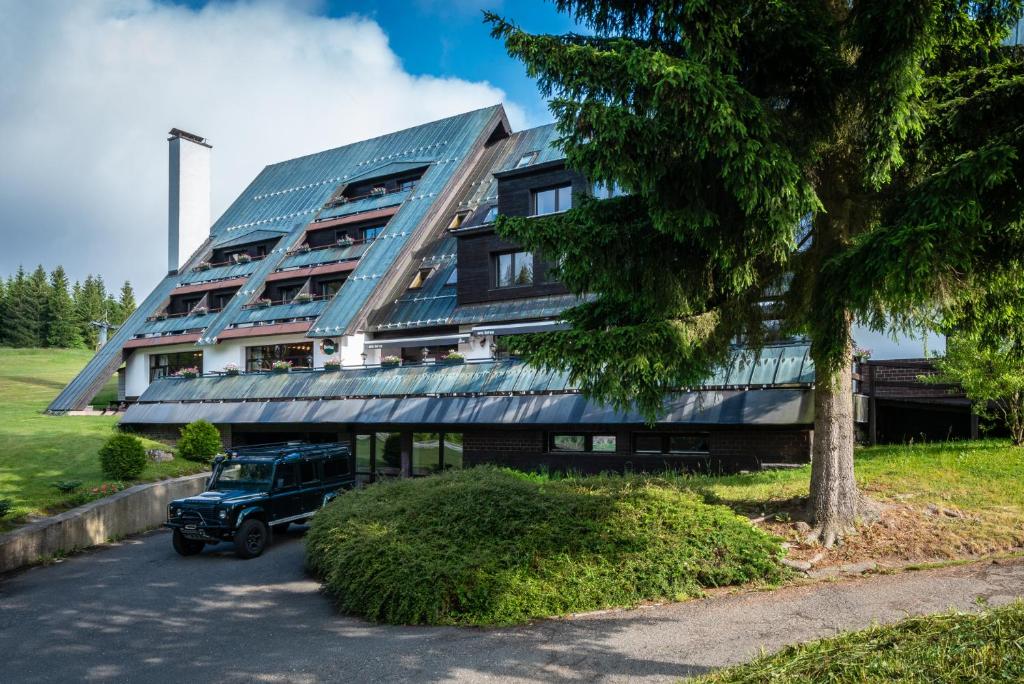 a truck parked in front of a building with solar panels at Wellness Hotel Šedý Vlk in Harrachov