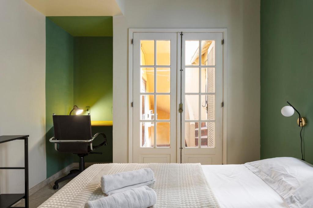 a bedroom with green walls and a bed and a chair at Chez Zany Boutique Hostel - Copacabana in Rio de Janeiro