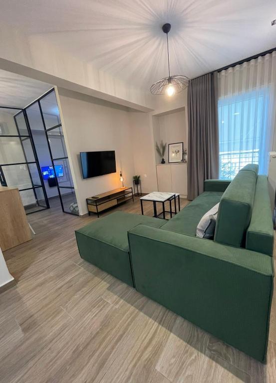 a living room with a green couch and a flat screen tv at Cashmere axd in Alexandroupoli