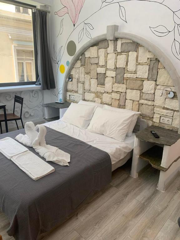 a bedroom with a large bed with a stone wall at Manello Home Art in Athens