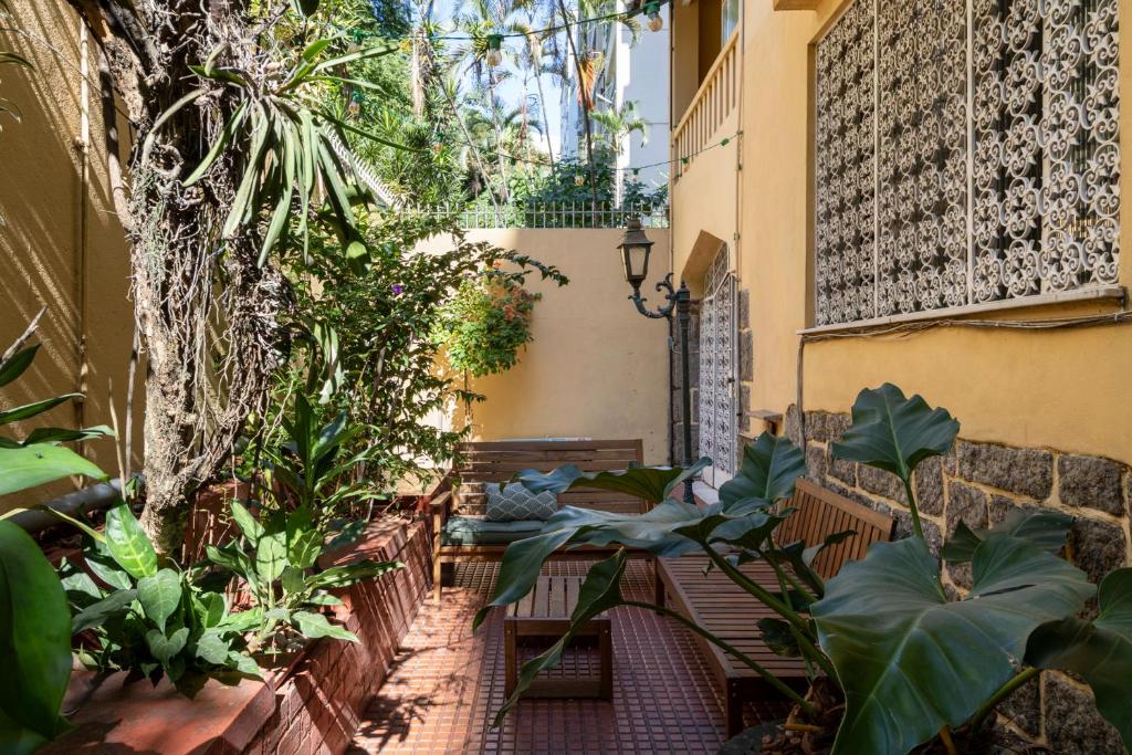 an outdoor patio with a table and chairs and plants at Chez Zany Boutique Hostel - Copacabana in Rio de Janeiro