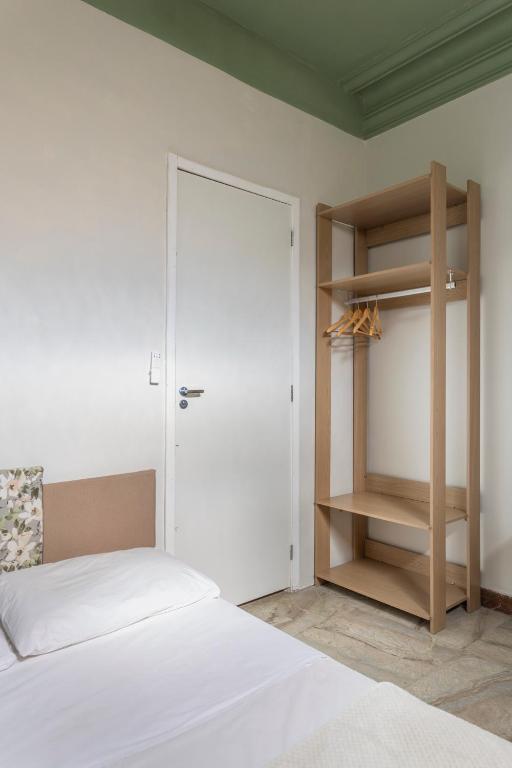 a bedroom with a white bed and a closet at Chez Zany Boutique Hostel - Copacabana in Rio de Janeiro