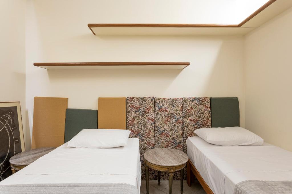 a room with two beds and a table at Chez Zany Boutique Hostel - Copacabana in Rio de Janeiro
