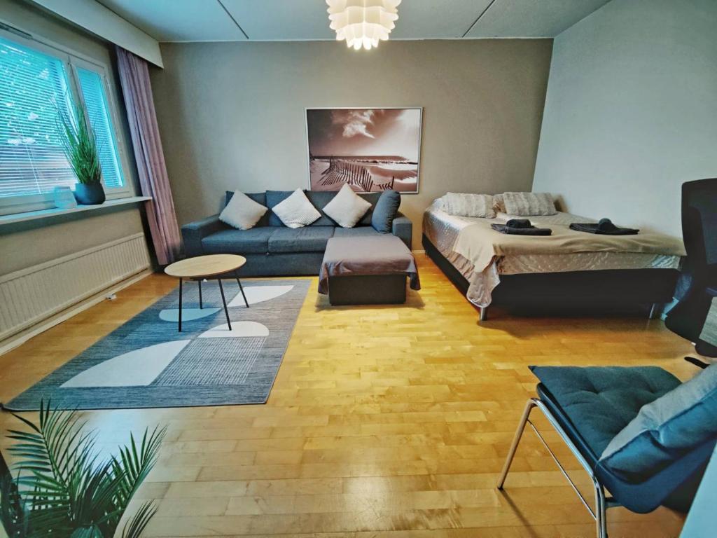 a living room with a couch and a bed at Mesikämmen - Free parking & WiFi - Next to the forest - Rating 9,4 in Jyväskylä