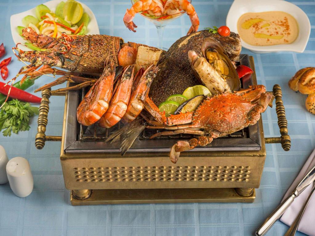 a plate of food with a crab and other foods at Movenpick Taba Resort & Spa in Taba