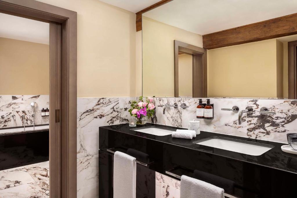un bagno con due lavandini e un grande specchio di NH Collection Palazzo Gaddi a Firenze