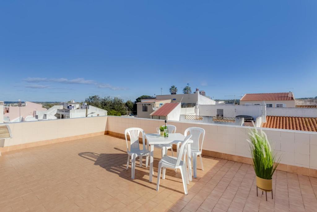 a patio with a table and chairs on a roof at Best Home 4 Family & Friends - Your Seaside Charm! in Odiáxere
