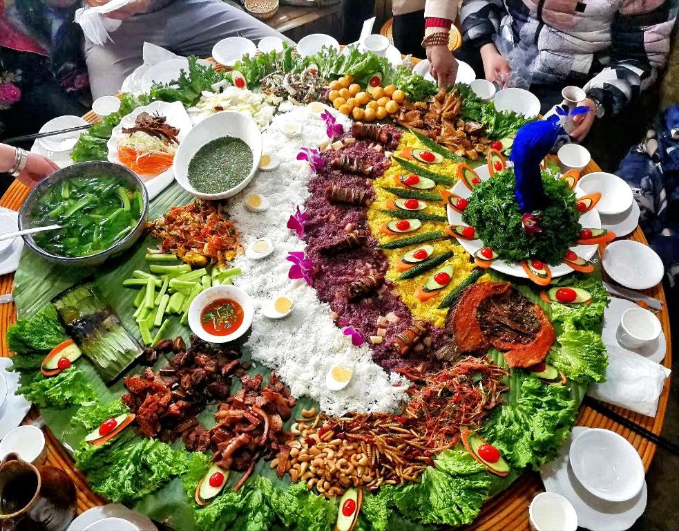 a table with a large amount of food on it at 原乡文苑客栈 in Lijiang