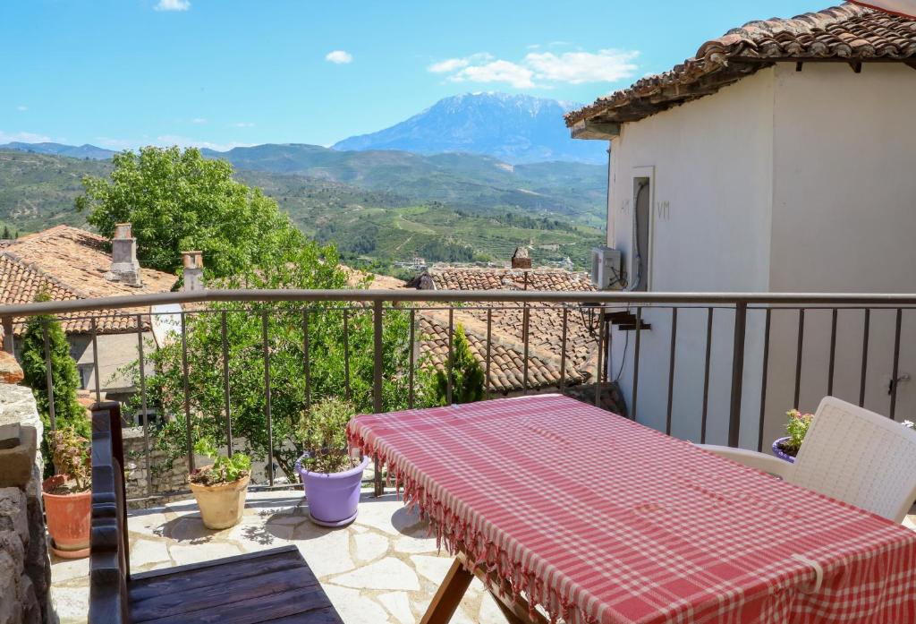 a balcony with a table and a view of a mountain at Guest House Vasili in Berat